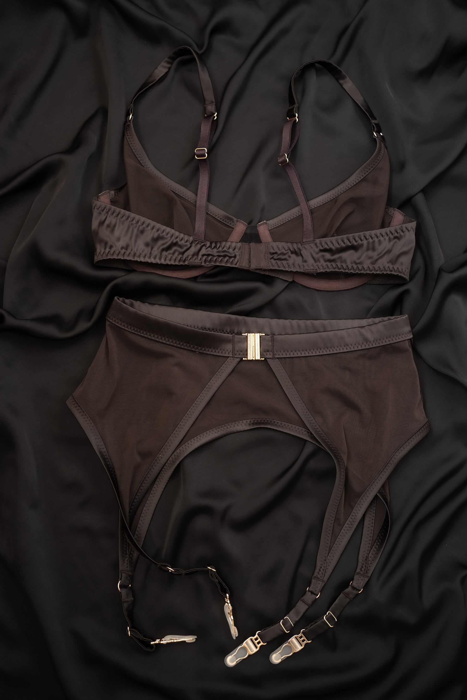 Brown lingerie Tate Chocolate set with garters on a black fabric background